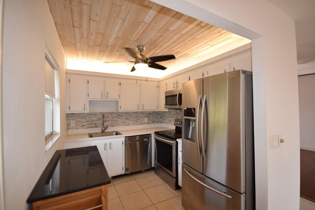 kitchen with tasteful backsplash, wood ceiling, ceiling fan, appliances with stainless steel finishes, and sink