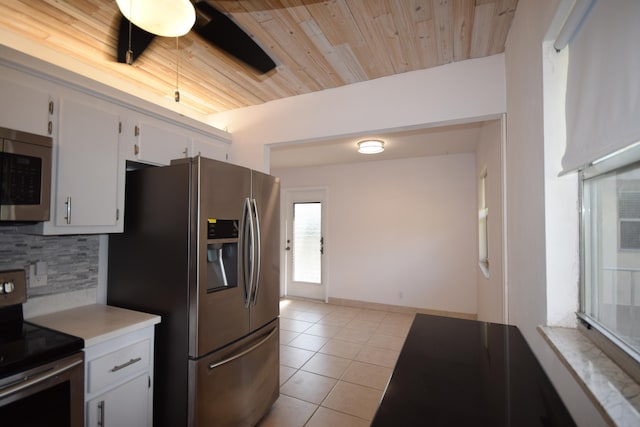 kitchen featuring light tile patterned flooring, white cabinets, appliances with stainless steel finishes, backsplash, and wood ceiling