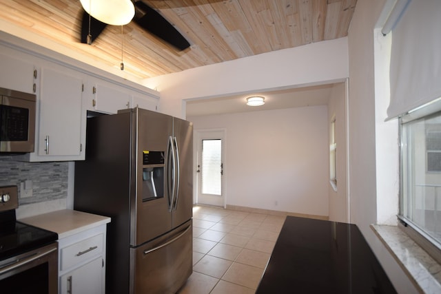 kitchen featuring white cabinetry, wood ceiling, tasteful backsplash, light tile patterned floors, and appliances with stainless steel finishes