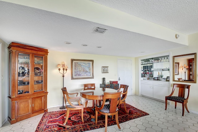 tiled dining area featuring a textured ceiling