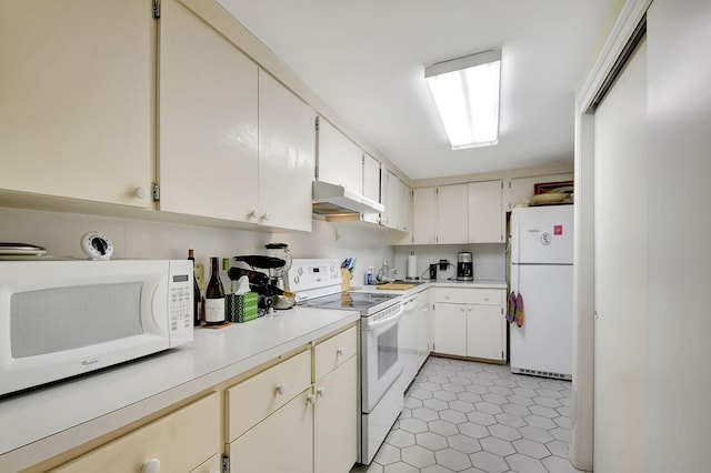 kitchen featuring sink, white cabinets, light tile patterned floors, and white appliances