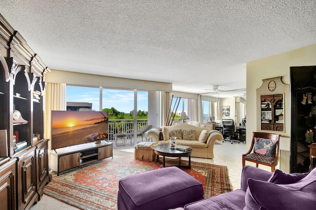 living room featuring a textured ceiling, ceiling fan, and light tile patterned floors