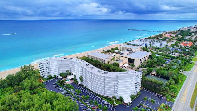 drone / aerial view featuring a beach view and a water view