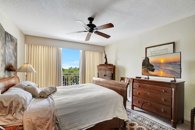 tiled bedroom with access to exterior, a textured ceiling, and ceiling fan