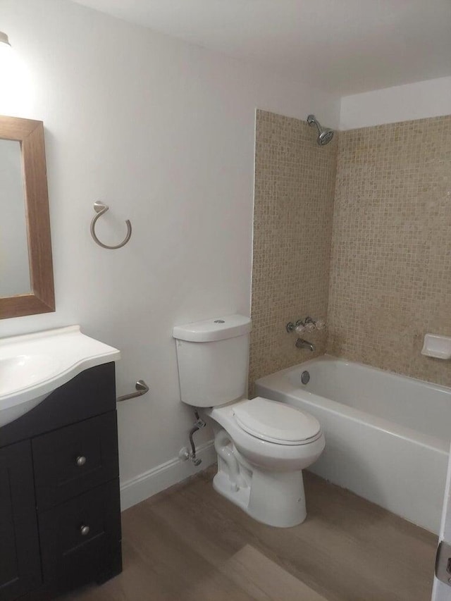 full bathroom with hardwood / wood-style flooring, vanity, toilet, and tiled shower / bath