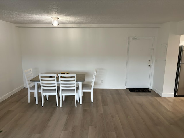 unfurnished dining area with hardwood / wood-style floors and a textured ceiling