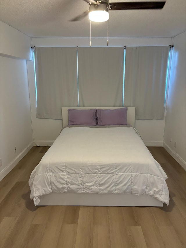 bedroom with ceiling fan and wood-type flooring