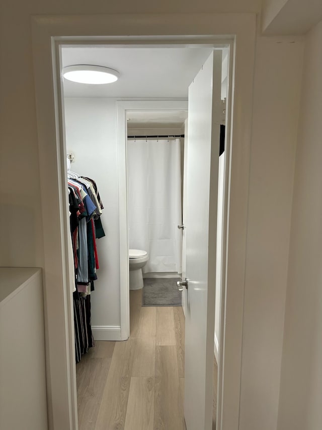 bathroom with toilet and hardwood / wood-style flooring