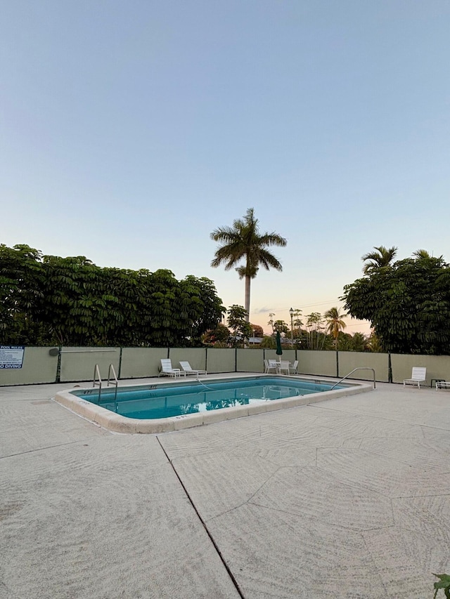 pool at dusk with a patio