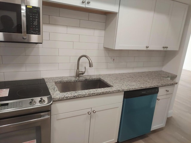 kitchen with sink, white cabinets, and appliances with stainless steel finishes