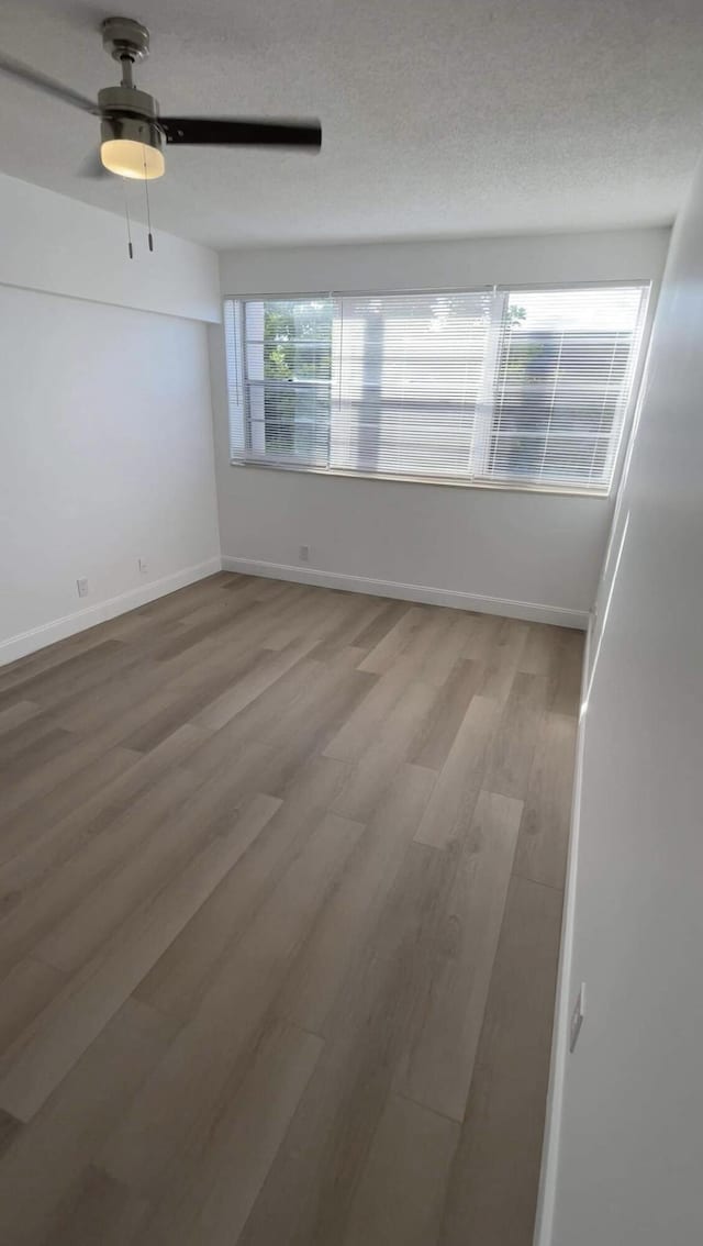 empty room with ceiling fan and wood-type flooring