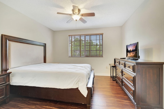 bedroom with ceiling fan, dark wood-type flooring, and a textured ceiling