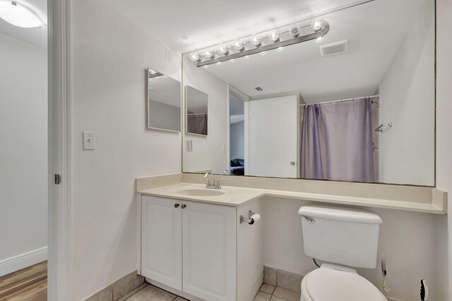 bedroom featuring a textured ceiling, a closet, light hardwood / wood-style flooring, and ceiling fan