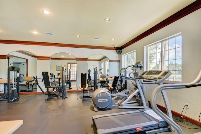 exercise room featuring decorative columns and crown molding