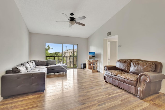 living room featuring hardwood / wood-style floors, ceiling fan, a textured ceiling, and vaulted ceiling