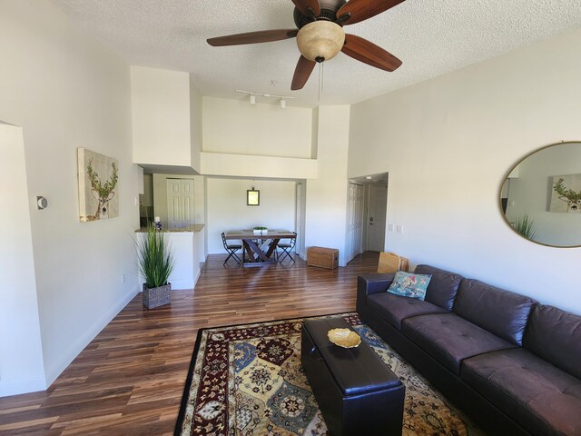 living room with ceiling fan, hardwood / wood-style floors, and a textured ceiling