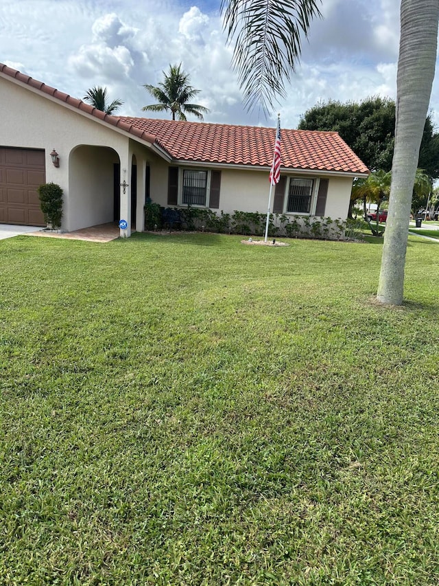 view of front of property featuring a garage and a front lawn