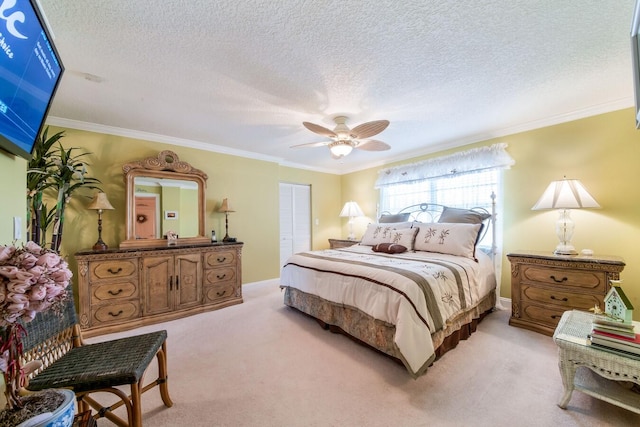 carpeted bedroom with a closet, ceiling fan, crown molding, and a textured ceiling