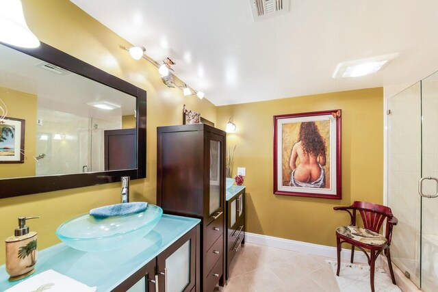 bathroom featuring walk in shower, vanity, and tile patterned flooring