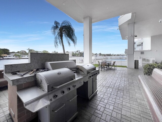 view of patio with a water view and a grill