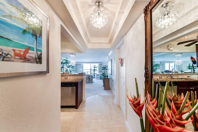 hall featuring a notable chandelier, light tile patterned floors, and sink