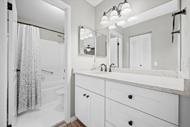 full bathroom with wood-type flooring, vanity, shower / bath combo, and toilet