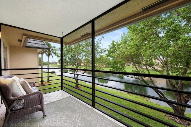 sunroom featuring a water view