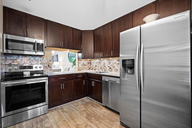 kitchen featuring light hardwood / wood-style flooring, tasteful backsplash, appliances with stainless steel finishes, sink, and dark brown cabinets