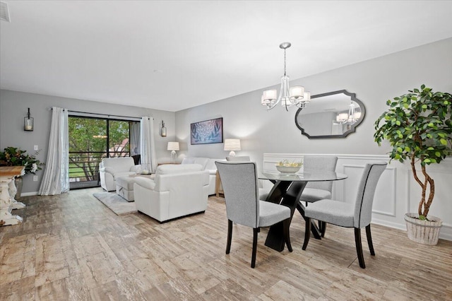 dining area with light hardwood / wood-style flooring and a chandelier