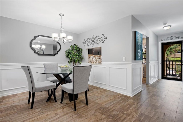 dining room with wood-type flooring and a notable chandelier