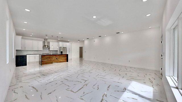 kitchen featuring white cabinets, light tile patterned floors, decorative backsplash, stainless steel refrigerator with ice dispenser, and wall chimney exhaust hood