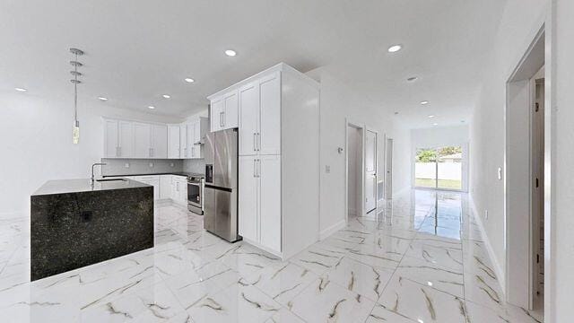 kitchen with white cabinets, stainless steel fridge, decorative light fixtures, light tile patterned floors, and decorative backsplash