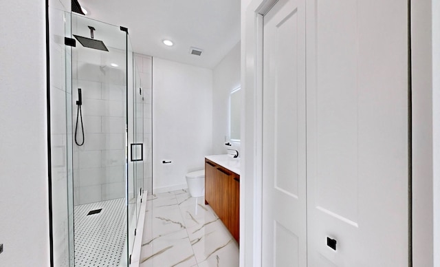 bathroom with a shower with shower door, vanity, tile patterned floors, and toilet