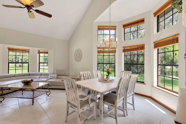 dining room with ceiling fan with notable chandelier, high vaulted ceiling, and light tile patterned flooring