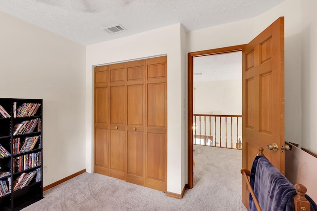 interior space with light carpet and a textured ceiling