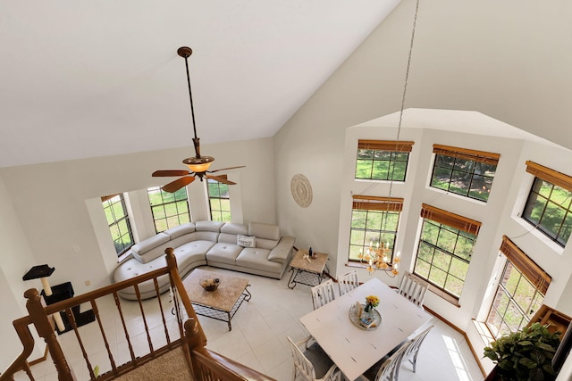 living room featuring ceiling fan with notable chandelier, high vaulted ceiling, and light tile patterned floors