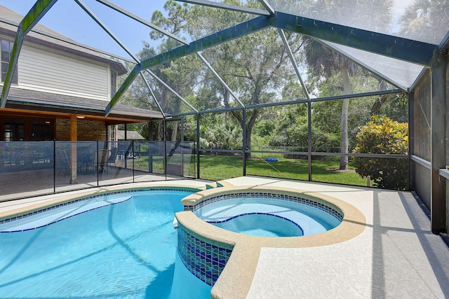 view of pool with a patio, glass enclosure, and an in ground hot tub