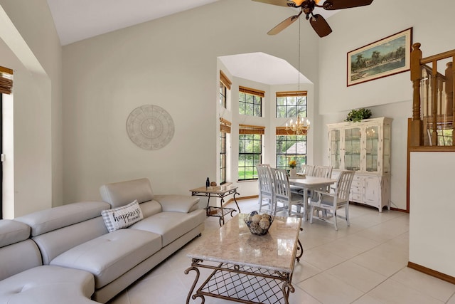 living room featuring ceiling fan with notable chandelier, high vaulted ceiling, and light tile patterned floors