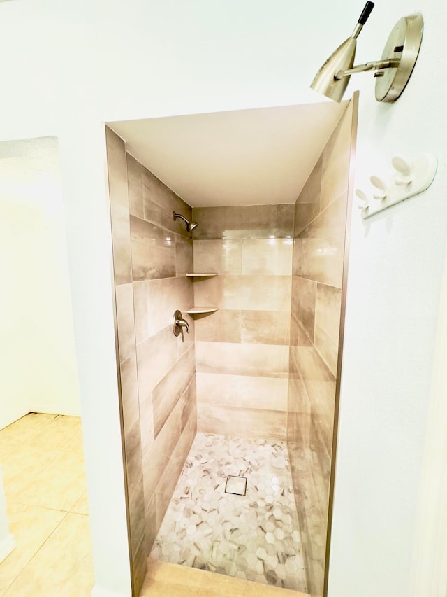 bathroom with tile patterned flooring and a tile shower