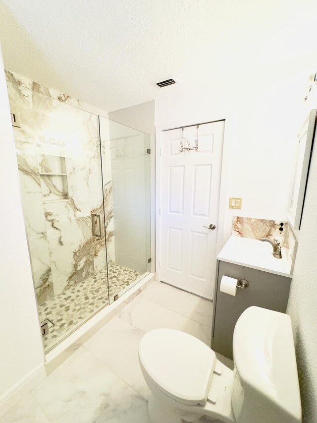 bathroom featuring a textured ceiling, walk in shower, vanity, and toilet