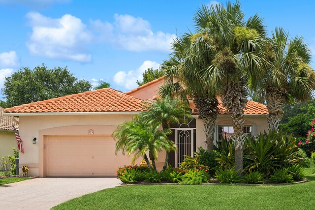 mediterranean / spanish house with a garage and a front yard