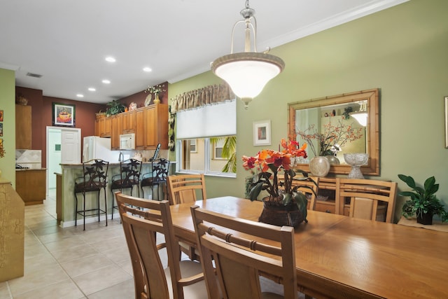 dining room featuring crown molding and light tile patterned floors