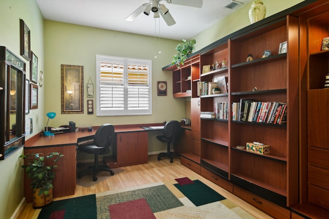 office area featuring built in desk, light hardwood / wood-style flooring, and ceiling fan