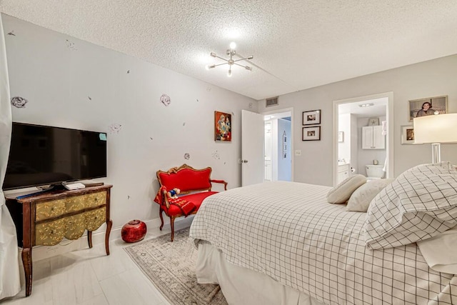 bedroom featuring ensuite bath and a textured ceiling