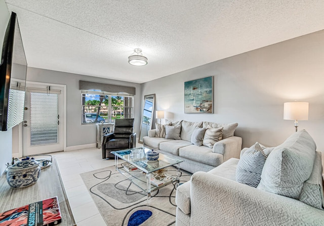 living room with a textured ceiling and light tile patterned floors