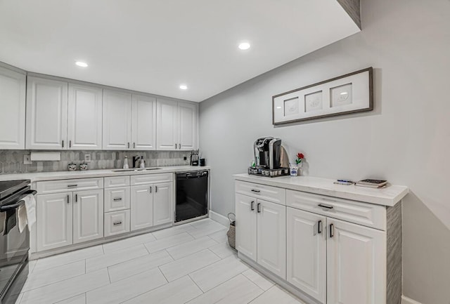 kitchen featuring sink, dishwasher, stove, tasteful backsplash, and white cabinets