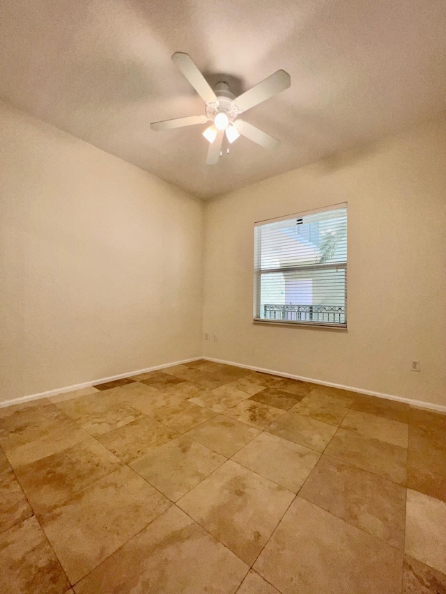 tiled empty room featuring ceiling fan