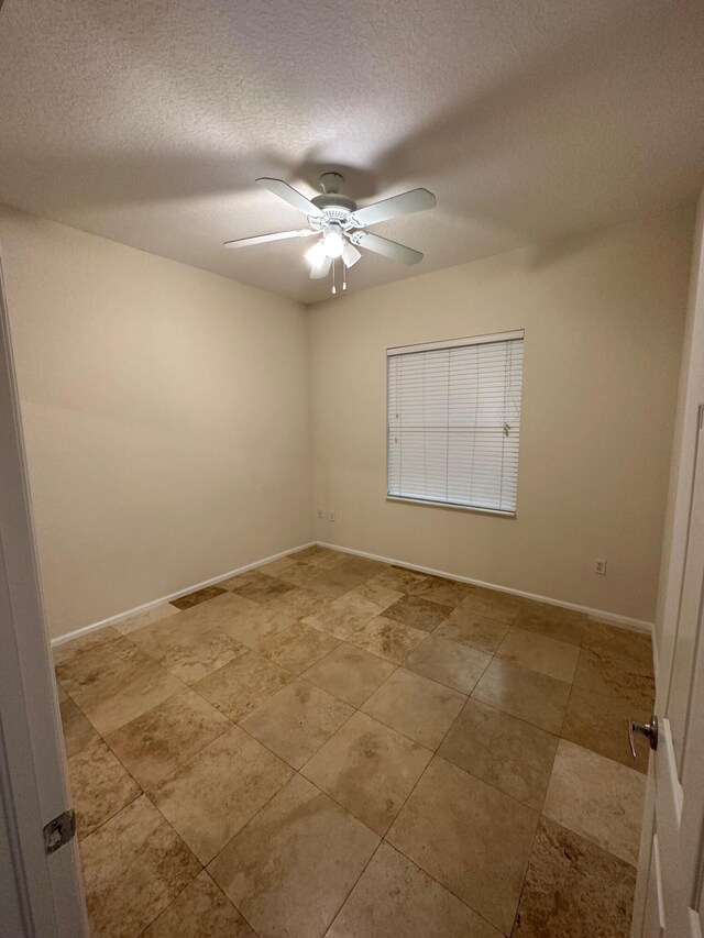 tiled spare room with ceiling fan and a textured ceiling