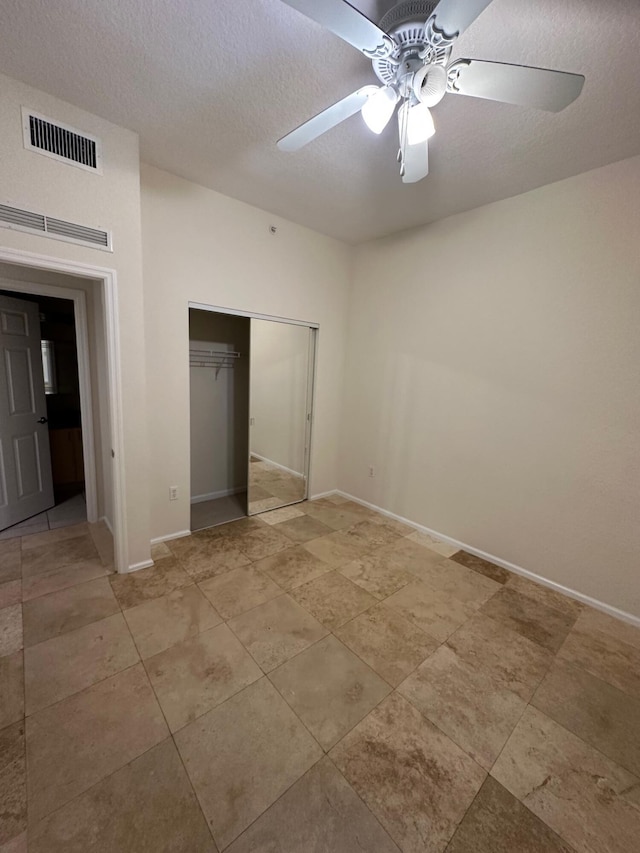 unfurnished bedroom with baseboards, a textured ceiling, visible vents, and a closet