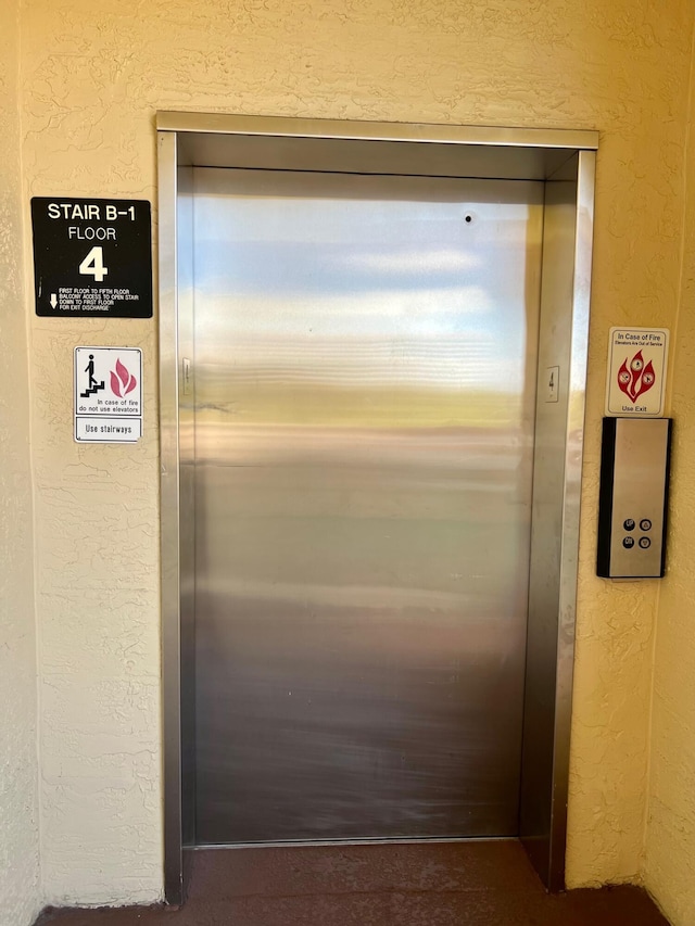 interior details featuring a textured wall and elevator